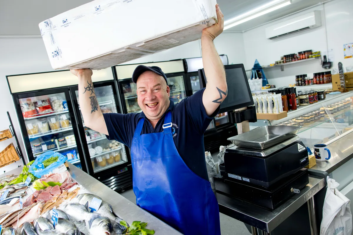 A Parkstone Fisheries team member with a fresh fish delivery box at our Poole shop